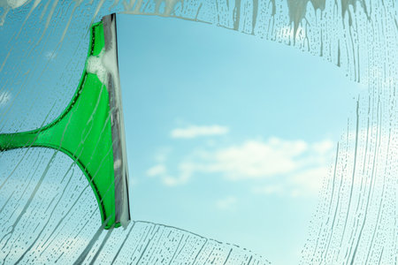 Cleaning window with squeegee on spring dayの写真素材