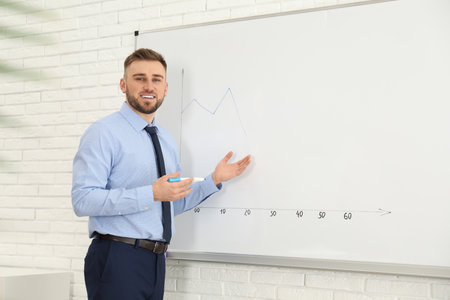Professional business trainer near whiteboard in officeの写真素材