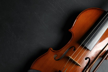 Classic violin and bow on black stone background, top view. Space for textの写真素材