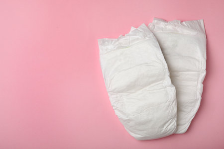 Baby diapers on pink background, top view. Space for textの写真素材