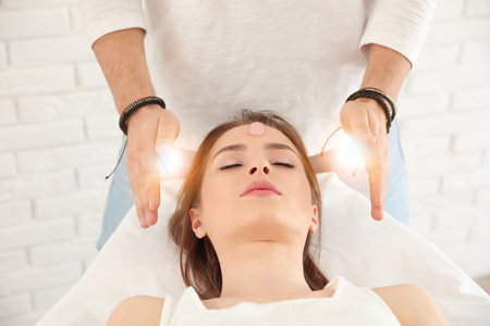 Young woman during crystal healing session in therapy roomの写真素材