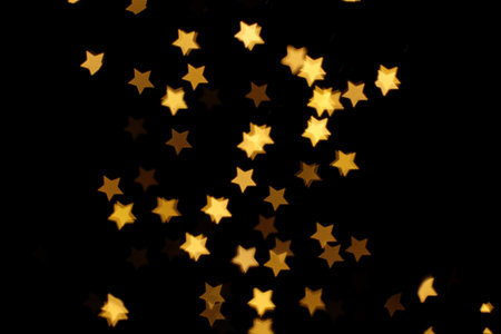 Blurred view of star shaped lights on black background. bokeh effectの写真素材