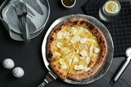 Tasty cheese pizza served on black table, flat lay