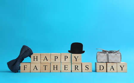 Wooden cubes with phrase HAPPY FATHER'S DAY on light blue backgroundの写真素材