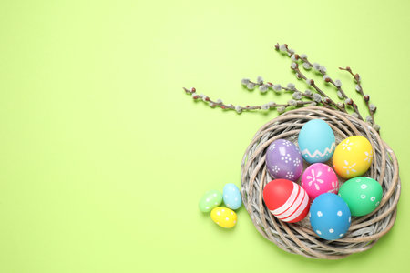 Flat lay composition with Easter eggs on green background. Space for text