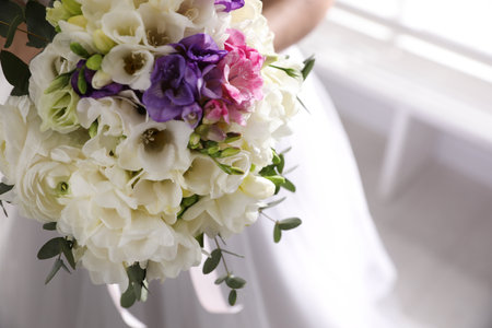 Bride holding beautiful bouquet with spring freesia flowers, closeupの写真素材