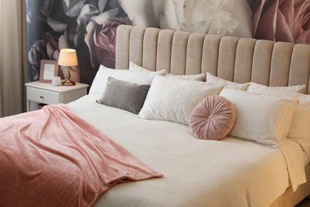 Large comfortable bed in beautiful room interiorの写真素材