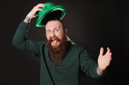 Bearded man with green hat on black background. St. Patrick's Day celebrationの写真素材