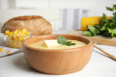 Delicious corn cream soup served on white wooden table