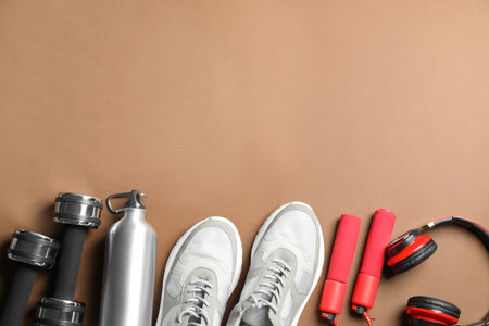 Flat lay composition with fitness equipment on brown background, space for textの写真素材