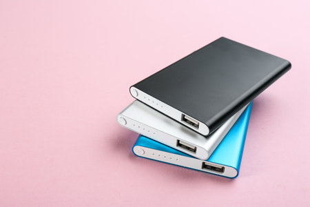 Modern external portable chargers on pink background
