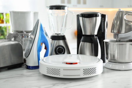 Set of modern home appliances in kitchen, focus on robotic vacuum cleanerの写真素材