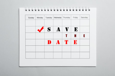 Blank calendar with phrase SAVE THE DATE on light gray background, top viewの写真素材
