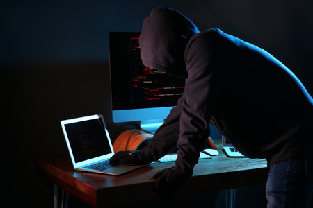 Hacker with computers in dark room. cybercrime