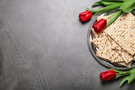 Flat lay composition with traditional Pesach (Passover Seder) matzo on gray table. Space for text