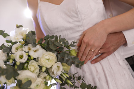 Happy newlywed couple with flowers in festive hall, closeupの写真素材