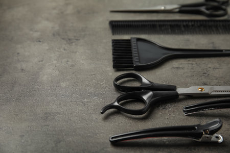 Professional tools for hair dyeing on gray stone background, space for textの写真素材