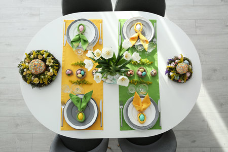 Festive Easter table setting with beautiful tulips and eggs, top view