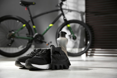Bicycle gloves, shoes and bottle on floorの写真素材