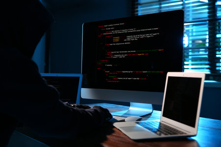 Hacker with computers in dark room. cybercrime