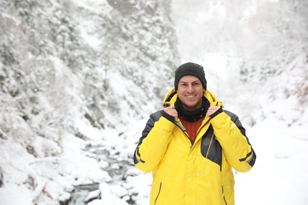 Handsome man wearing warm clothes outdoors on snowy day. winter holidaysの写真素材