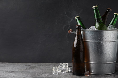 Metal bucket with beer and ice cubes on gray background. Space for textの写真素材