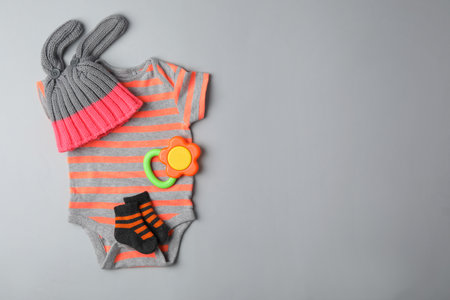 Flat lay composition with child's clothes and teether on gray background, space for textの写真素材