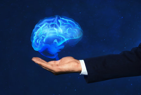 Young man holding digital image of brain on blue background, closeupの写真素材
