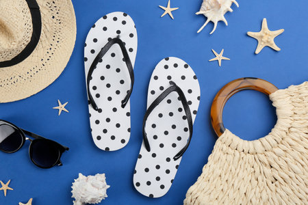 Flat lay composition with flip flops and beach accessories on blue backgroundの写真素材