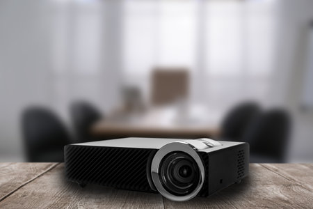 Modern video projector and blurred conference room on backgroundの写真素材