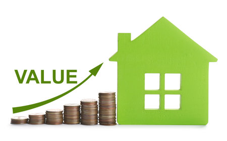 Model of house and stacked coins on white background. Growing valueの写真素材