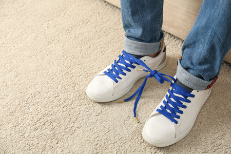 Man wearing sneakers with tied together laces, closeup. April fool's dayの写真素材