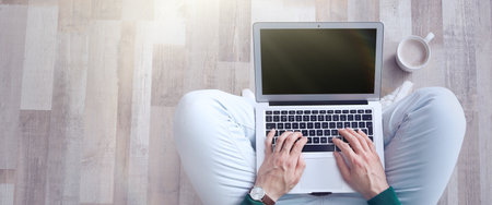 Young man working on computer indoors, top view with space for text. banner design