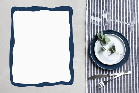 Elegant table setting and empty menu on gray marble table, flat lay. Space for text