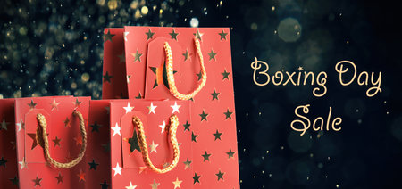 Boxing day sale. Shopping bags and blurred lights on dark background, banner designの写真素材