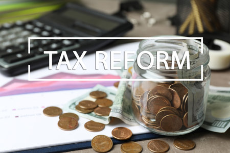 Glass jar with money on table. tax reformの写真素材