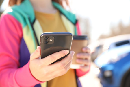 Woman holding Phone outdoors, closeup