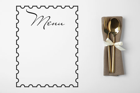 Cutlery set and empty menu on white background, top view. Space for textの写真素材