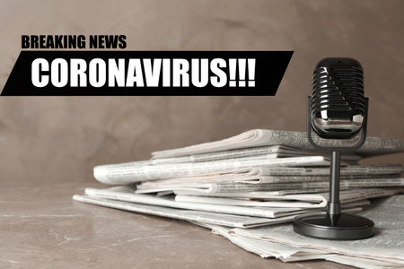 Word CORONAVIRUS, newspapers and vintage microphone on marble table. Journalist's workの写真素材