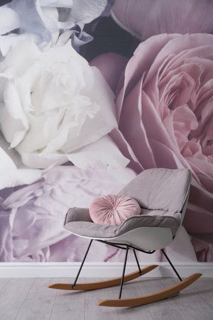 Comfortable rocking-chair near wall with floral wallpaper. Stylish living room interiorの写真素材