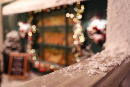 Wooden railing with snow on blurred background, closeup. Christmas celebrationの写真素材