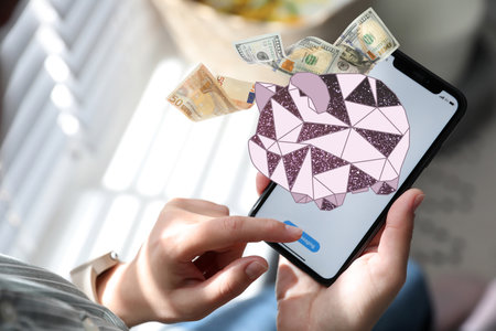Woman using online bank application on her smartphone indoorsの写真素材
