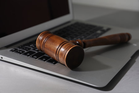 Laptop and wooden gavel on light table. cybercrime