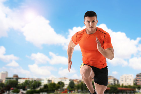 Athletic young man running on sunny day, space for text