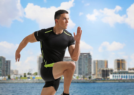 Athletic young man running near the sea on a sunny day