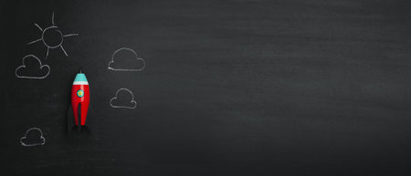 Bright toy rocket and drawings on chalkboard, flat lay with space for text. banner designの写真素材
