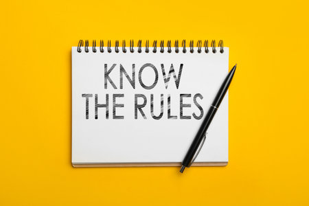 Notebook with phrase Know the rules and pen on yellow background, top viewの写真素材
