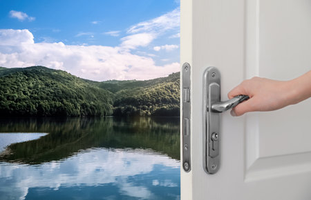 Woman opening door to lake on sunny day, closeupの写真素材