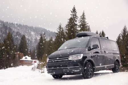 Black car on snowy road. winter holidays