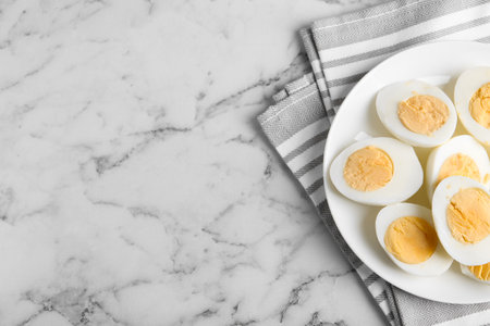 Tasty hard boiled eggs on white marble table, flat lay. Space for textの写真素材